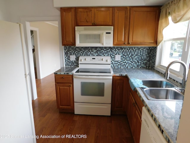 1305 May St, Lansing, MI 48906 - kitchen featuring white appliances, dark wood-type flooring, brown cabinets, and a sink