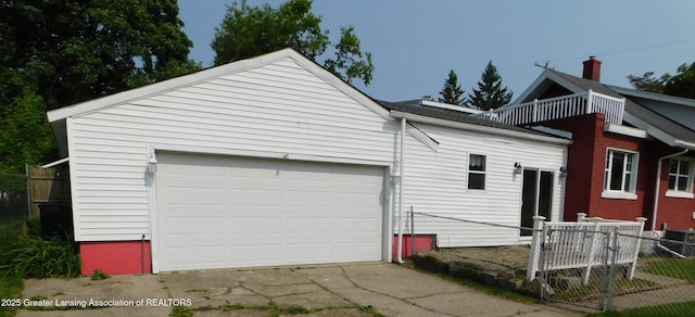 1305 May St, Lansing, MI 48906 - back of property featuring concrete driveway, central air condition unit, and a garage