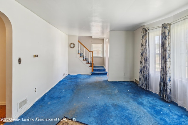 1615 Inverness Ave, Lansing, MI 48915 - carpeted empty room featuring arched walkways, plenty of natural light, stairs, and baseboards