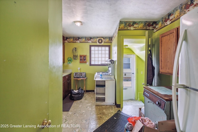 1615 Inverness Ave, Lansing, MI 48915 - kitchen featuring freestanding refrigerator, a textured ceiling, and baseboards
