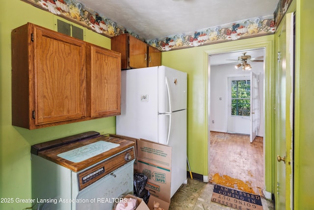 1615 Inverness Ave, Lansing, MI 48915 - kitchen featuring freestanding refrigerator, a ceiling fan, and brown cabinets