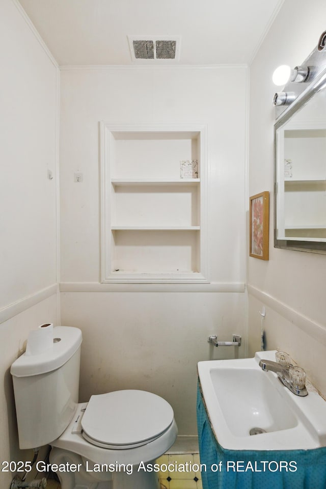 1615 Inverness Ave, Lansing, MI 48915 - bathroom with toilet, vanity, ornamental molding, and built in features