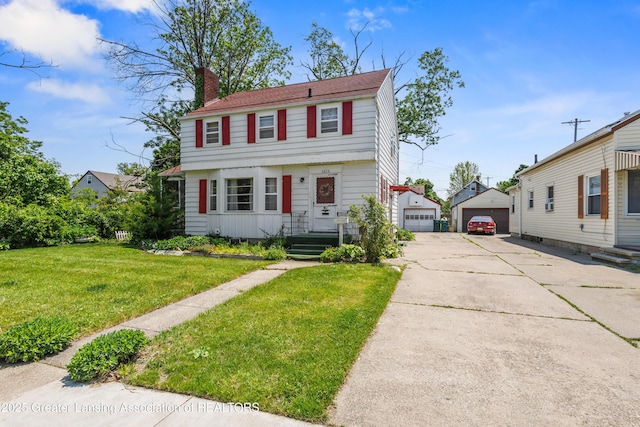 1615 Inverness Ave, Lansing, MI 48915 - colonial house featuring a detached garage, a chimney, an outbuilding, and a front lawn