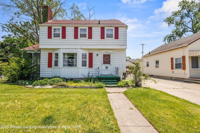 1615 Inverness Ave, Lansing, MI 48915 - colonial-style house featuring a chimney and a front yard