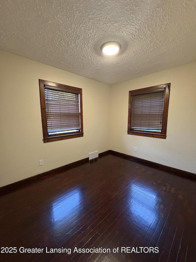 1524 Roseneath Ave, Lansing, MI 48915 - empty room featuring a textured ceiling, dark wood finished floors, and baseboards