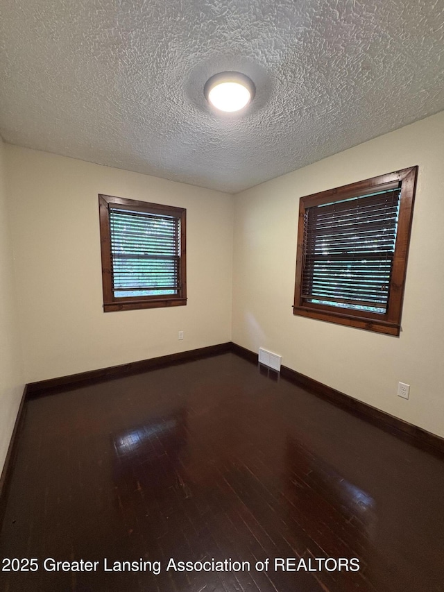 1524 Roseneath Ave, Lansing, MI 48915 - spare room featuring wood finished floors, a textured ceiling, and baseboards