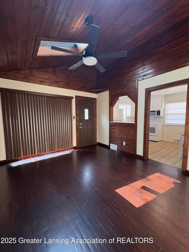 1524 Roseneath Ave, Lansing, MI 48915 - unfurnished living room featuring ceiling fan, vaulted ceiling, wood ceiling, wooden walls, and hardwood / wood-style flooring