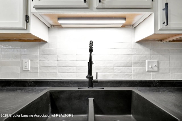 4003 Norfolk Ct, Lansing, MI 48910 - kitchen view of a sink, dark countertops, and decorative backsplash