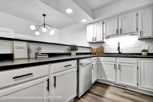 4003 Norfolk Ct, Lansing, MI 48910 - kitchen with a sink, dishwasher, dark countertops, white cabinets, and recessed lighting