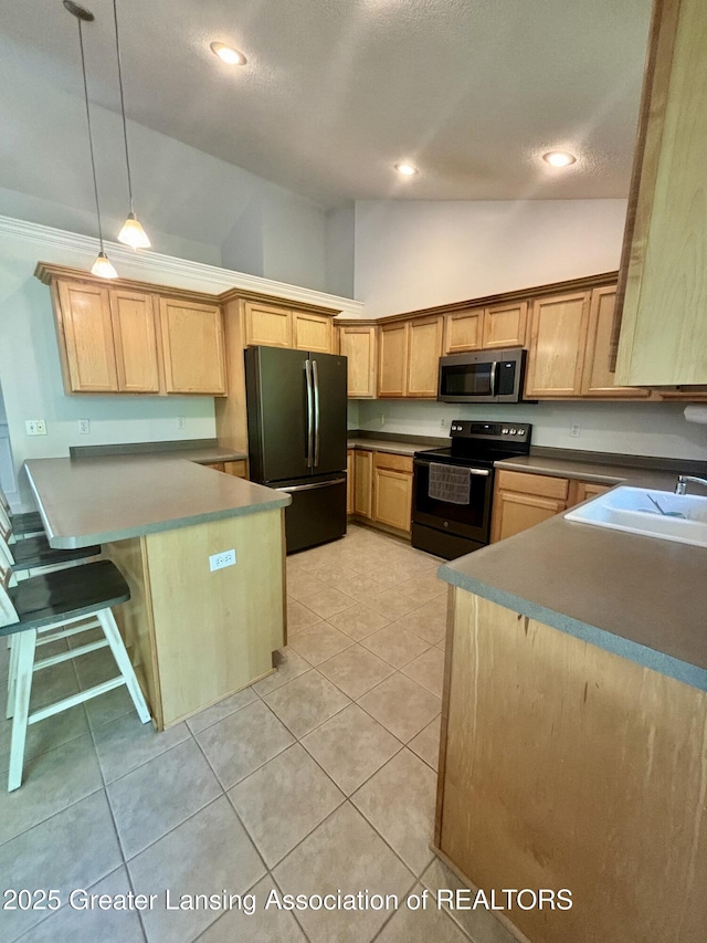 1826 Battle Creek Rd, Charlotte, MI 48813 - kitchen with black appliances, a peninsula, hanging light fixtures, light tile patterned floors, and high vaulted ceiling