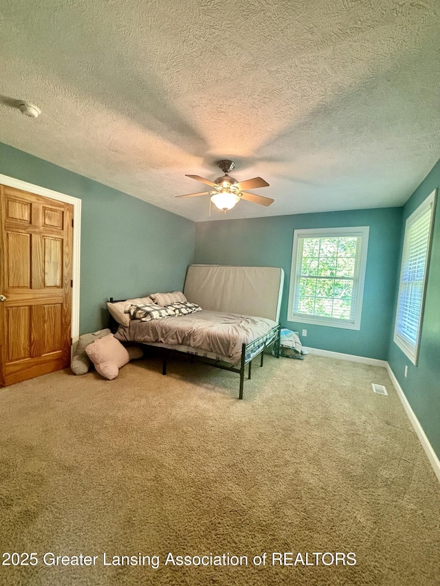 1826 Battle Creek Rd, Charlotte, MI 48813 - carpeted bedroom featuring a textured ceiling, baseboards, and ceiling fan