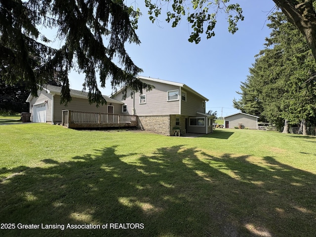 1064 W Shepherd St, Charlotte, MI 48813 - view of green lawn featuring a deck and an attached garage