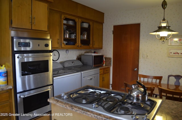 408 Whitehills Dr, East Lansing, MI 48823 - kitchen with stainless steel appliances, separate washer and dryer, wallpapered walls, brown cabinetry, and glass insert cabinets