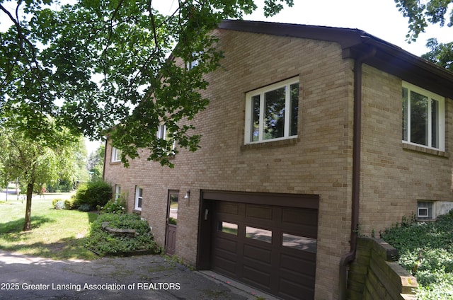 408 Whitehills Dr, East Lansing, MI 48823 - view of home's exterior with a garage and brick siding