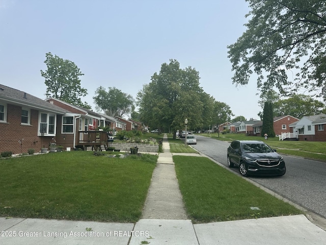 2107 Westbury Rd, Lansing, MI 48906 - view of asphalt street with sidewalks, a residential view, and curbs