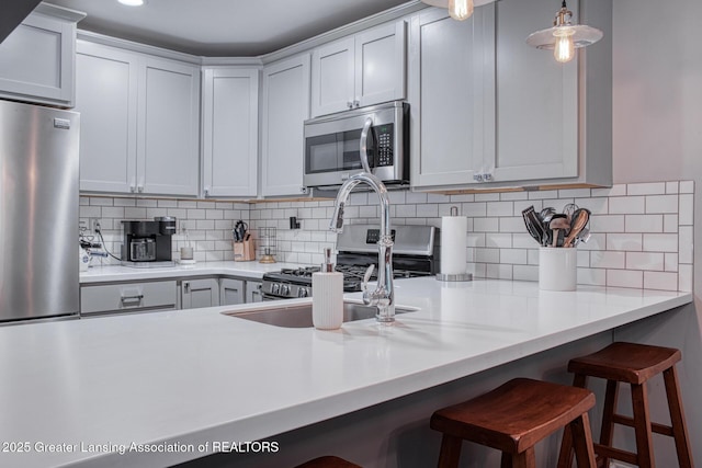 3635 E Meadows Ct, Okemos, MI 48864 - kitchen featuring stainless steel microwave, a kitchen breakfast bar, backsplash, and light countertops