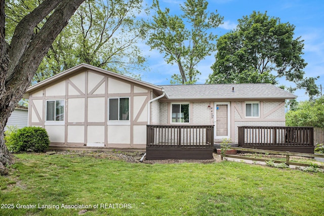 4425 Doncaster Ave, Holt, MI 48842 - rear view of property with a deck, brick siding, and a lawn