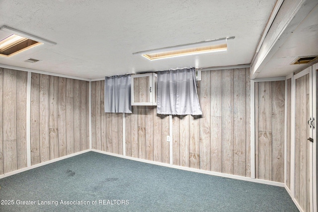 4425 Doncaster Ave, Holt, MI 48842 - finished below grade area featuring wooden walls, a textured ceiling, and carpet flooring