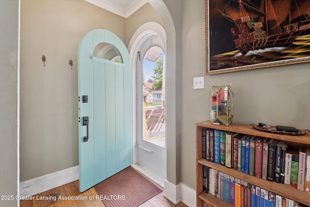1928 Teel Ave, Lansing, MI 48910 - foyer entrance with arched walkways, healthy amount of natural light, baseboards, ornamental molding, and wood finished floors
