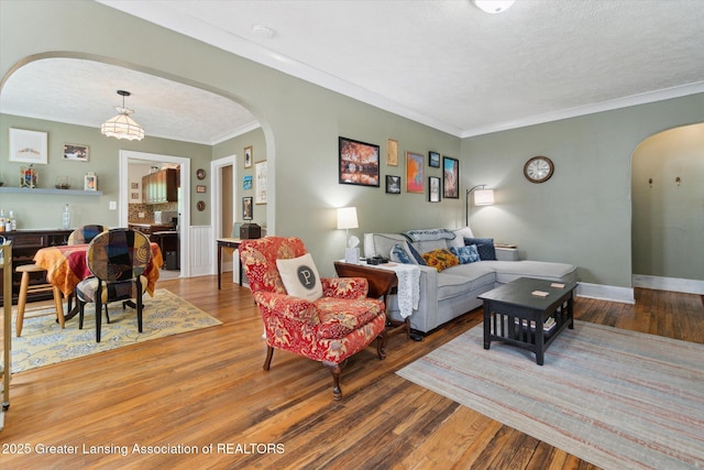 1928 Teel Ave, Lansing, MI 48910 - living area with arched walkways, wood finished floors, crown molding, a textured ceiling, and baseboards