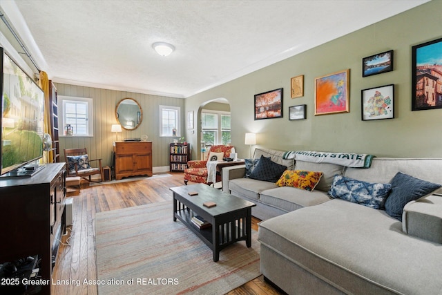 1928 Teel Ave, Lansing, MI 48910 - living area featuring wood finished floors, arched walkways, plenty of natural light, ornamental molding, and a textured ceiling