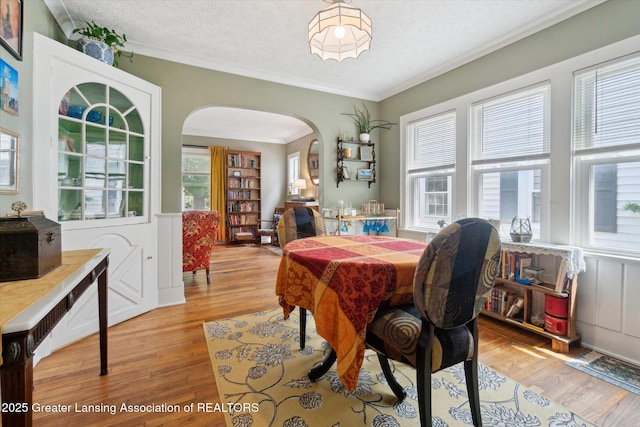 1928 Teel Ave, Lansing, MI 48910 - dining space featuring arched walkways, wood finished floors, crown molding, and a textured ceiling