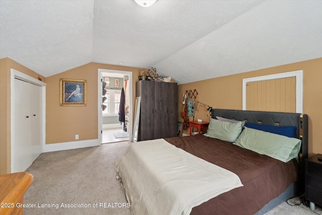 1928 Teel Ave, Lansing, MI 48910 - carpeted bedroom featuring lofted ceiling, a textured ceiling, ensuite bathroom, and baseboards