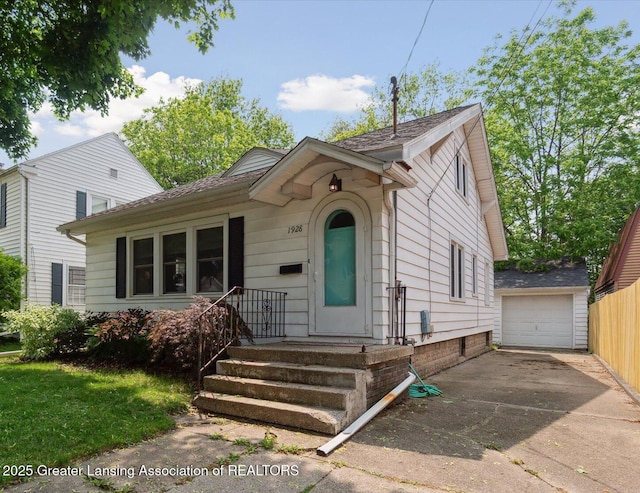 1928 Teel Ave, Lansing, MI 48910 - view of front of house featuring concrete driveway, an outbuilding, and a garage