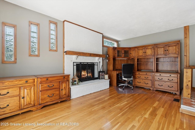 4663 Sycamore St, Holt, MI 48842 - office area featuring a fireplace and light wood-style floors