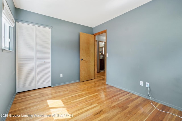 4663 Sycamore St, Holt, MI 48842 - unfurnished bedroom with a closet, wood finished floors, and baseboards