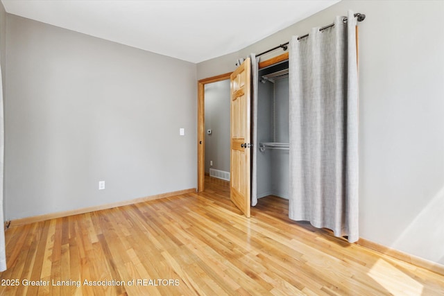 4663 Sycamore St, Holt, MI 48842 - unfurnished bedroom featuring a closet, light wood finished floors, and baseboards