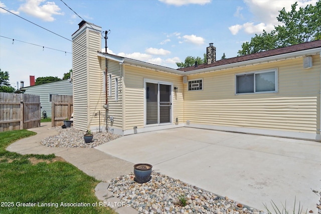 4663 Sycamore St, Holt, MI 48842 - rear view of house with a chimney and a patio area