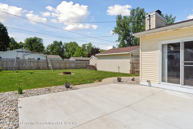 4663 Sycamore St, Holt, MI 48842 - view of patio featuring a fire pit and an outbuilding