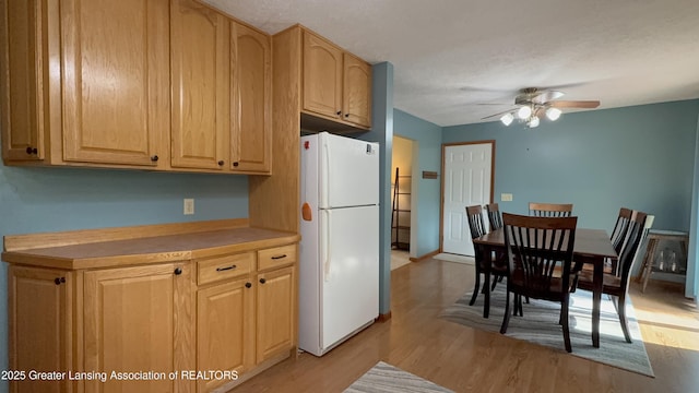 9216 S Grove Rd, Dewitt, MI 48820 - kitchen with freestanding refrigerator, a ceiling fan, light wood-type flooring, light countertops, and light brown cabinetry