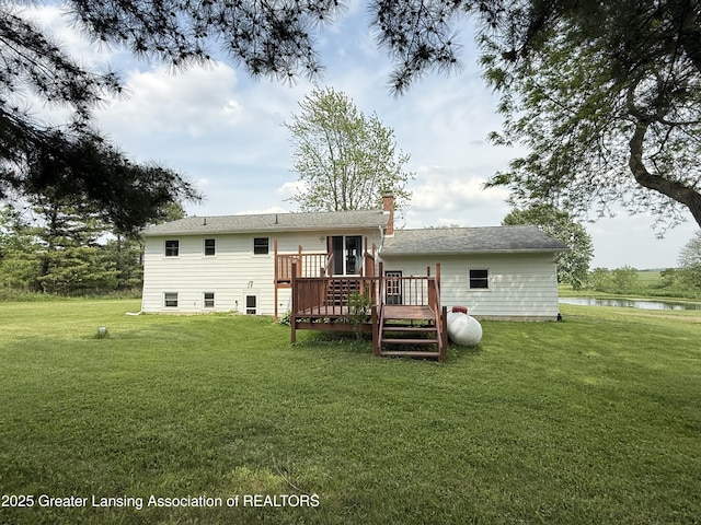9216 S Grove Rd, Dewitt, MI 48820 - rear view of property with a deck with water view, a lawn, and a chimney