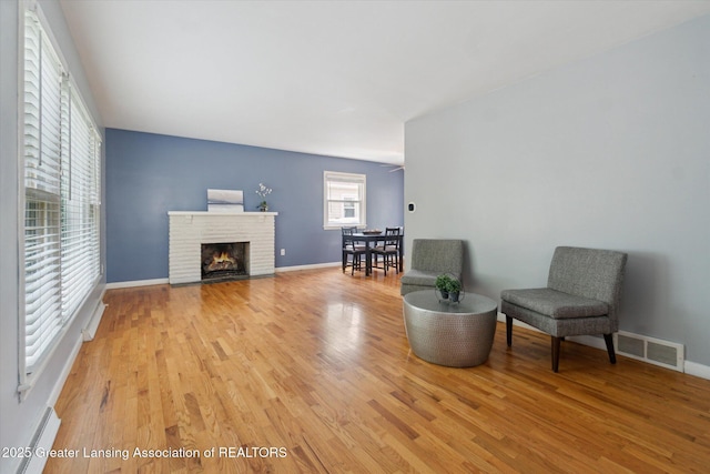 1023 N Hayford Ave, Lansing, MI 48912 - sitting room with light wood-style floors, a brick fireplace, and baseboards