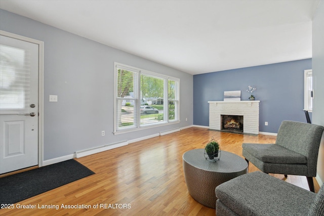 1023 N Hayford Ave, Lansing, MI 48912 - living area featuring a baseboard radiator, a fireplace, light wood finished floors, and baseboards