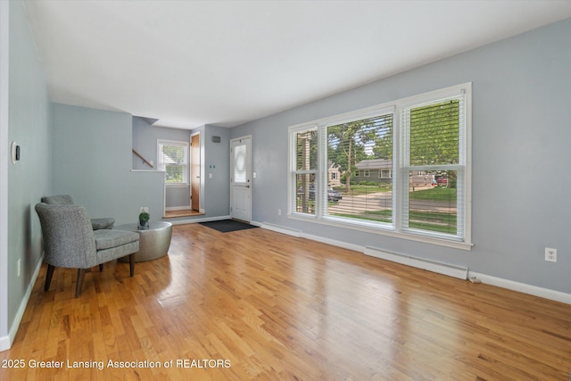 1023 N Hayford Ave, Lansing, MI 48912 - entrance foyer featuring a baseboard heating unit, light wood-style floors, baseboards, and stairway