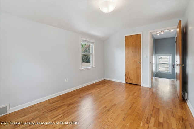 1023 N Hayford Ave, Lansing, MI 48912 - unfurnished bedroom featuring light wood finished floors, vaulted ceiling, and baseboards