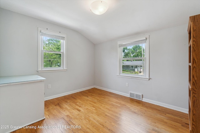 1023 N Hayford Ave, Lansing, MI 48912 - spare room with vaulted ceiling, light wood-type flooring, plenty of natural light, and baseboards