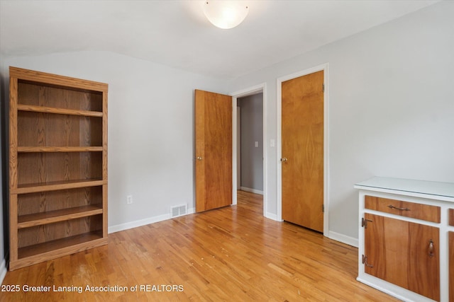 1023 N Hayford Ave, Lansing, MI 48912 - unfurnished bedroom featuring light wood-style floors, baseboards, and vaulted ceiling