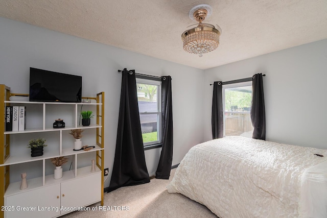 522 W Hodge Ave, Lansing, MI 48910 - bedroom with carpet floors, a chandelier, and a textured ceiling