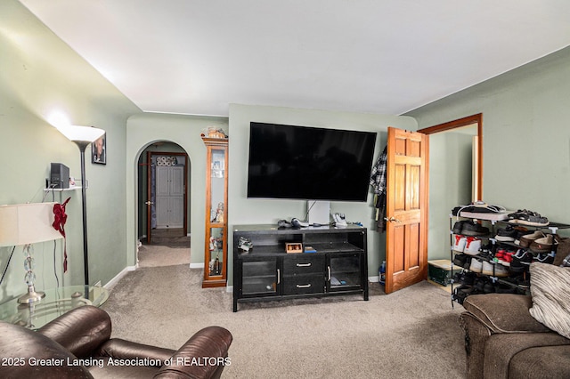 6327 Grovenburg Rd, Lansing, MI 48911 - living area featuring carpet floors, arched walkways, and baseboards