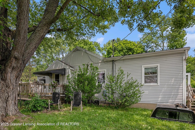 6327 Grovenburg Rd, Lansing, MI 48911 - rear view of property with a wooden deck and a yard