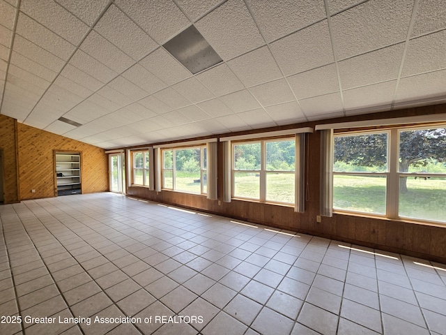 6322 Springport Rd, Eaton Rapids, MI 48827 - unfurnished living room with wood walls and tile patterned floors