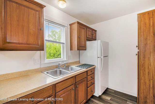 413 N Pennsylvania Ave, Lansing, MI 48912 - kitchen with a sink, brown cabinets, dark wood-style flooring, and freestanding refrigerator