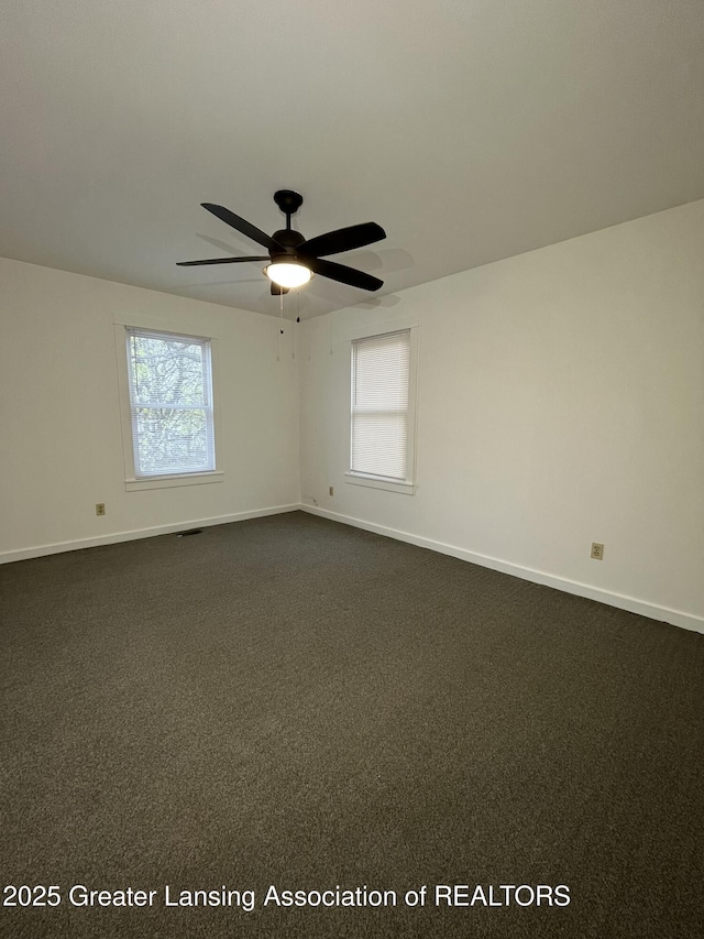 413 N Pennsylvania Ave, Lansing, MI 48912 - spare room with baseboards, a ceiling fan, and dark carpet