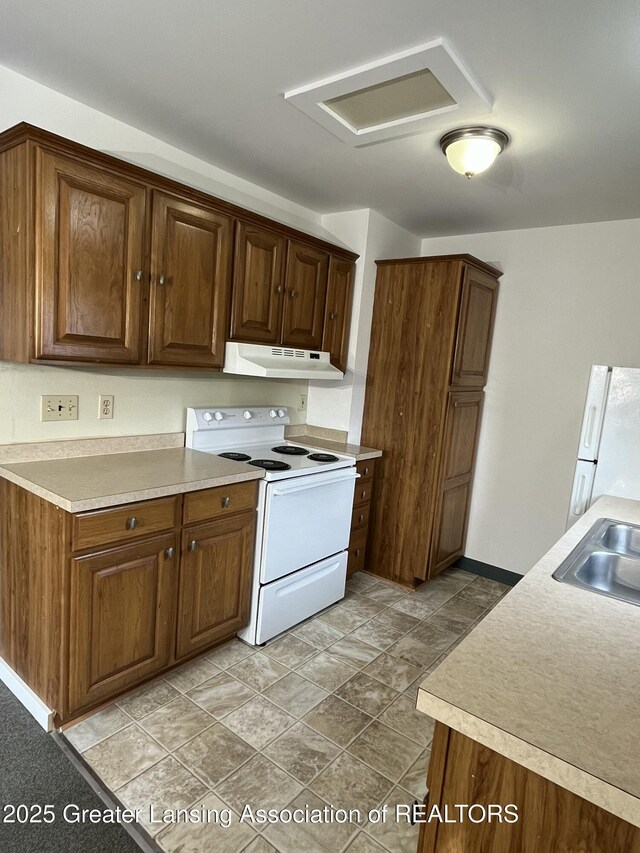 413 N Pennsylvania Ave, Lansing, MI 48912 - kitchen featuring white appliances, under cabinet range hood, a sink, and light countertops