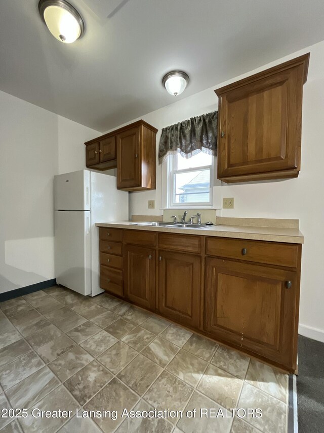 413 N Pennsylvania Ave, Lansing, MI 48912 - kitchen with baseboards, light countertops, a sink, and freestanding refrigerator