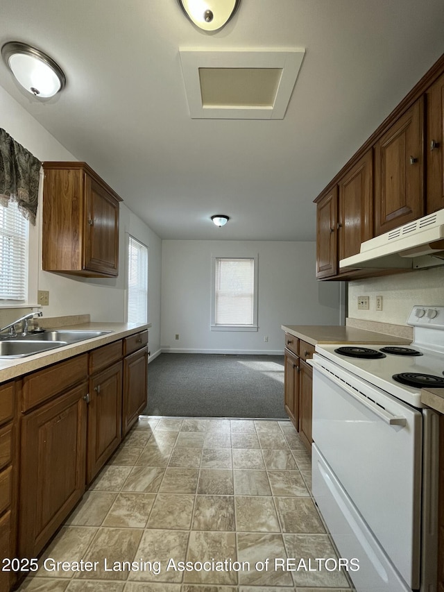 413 N Pennsylvania Ave, Lansing, MI 48912 - kitchen featuring white electric stove, a sink, under cabinet range hood, light carpet, and light countertops
